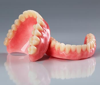 Dentures Waterloo ON holding best denture set in hands